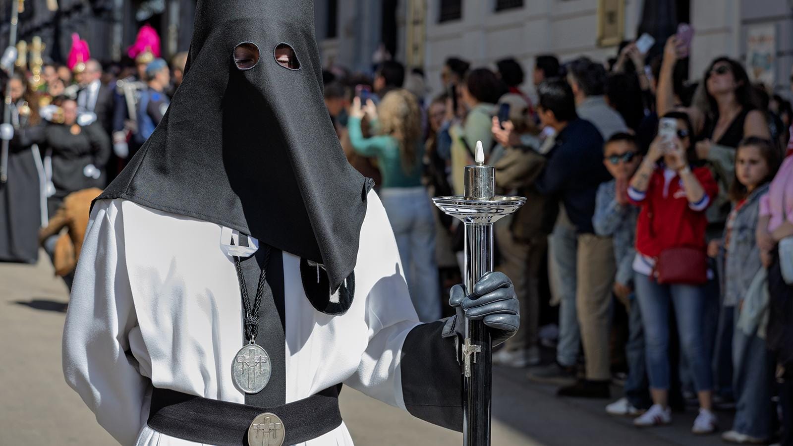 Público grabando con teléfonos móviles el paso de una procesión de Semana Santa.