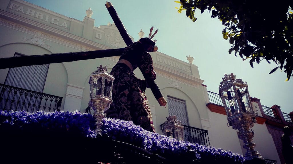 Cristo nazareno con túnica morada bordada en oro durante una procesión de Semana Santa en Paradas, Sevilla.