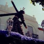 Cristo nazareno con túnica morada bordada en oro durante una procesión de Semana Santa en Paradas, Sevilla.
