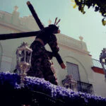 Cristo nazareno con túnica morada bordada en oro durante una procesión de Semana Santa en Paradas, Sevilla.