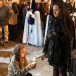 Procesión de Semana Santa en Granada contemplada desde la calle entre público y nazarenos.