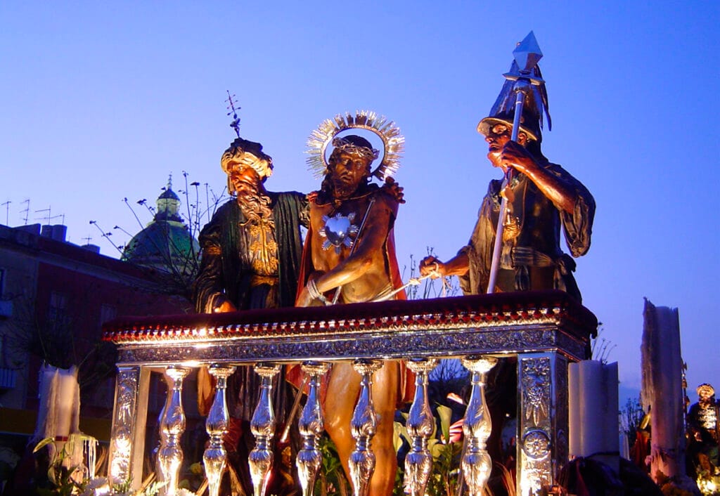 Grupo escultórico de Ecce Homo iluminado al anochecer en la Procesión de los Misterios de Trapani.