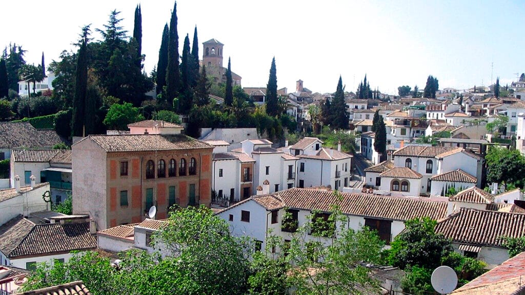 Calle del Albaicín de Granada con casas encaladas y trazado tradicional del barrio.