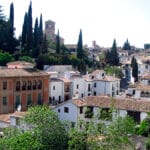 Calle del Albaicín de Granada con casas encaladas y trazado tradicional del barrio.