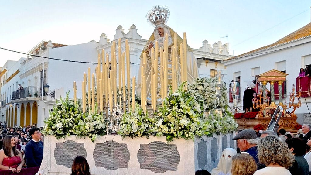 Paso de la Virgen del Rosario durante la Semana Santa de Moguer ante el público congregado en la calle.