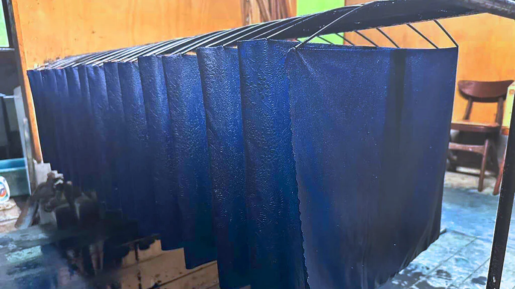 Tela teñida con índigo al ser levantada de una cuba de tinte.