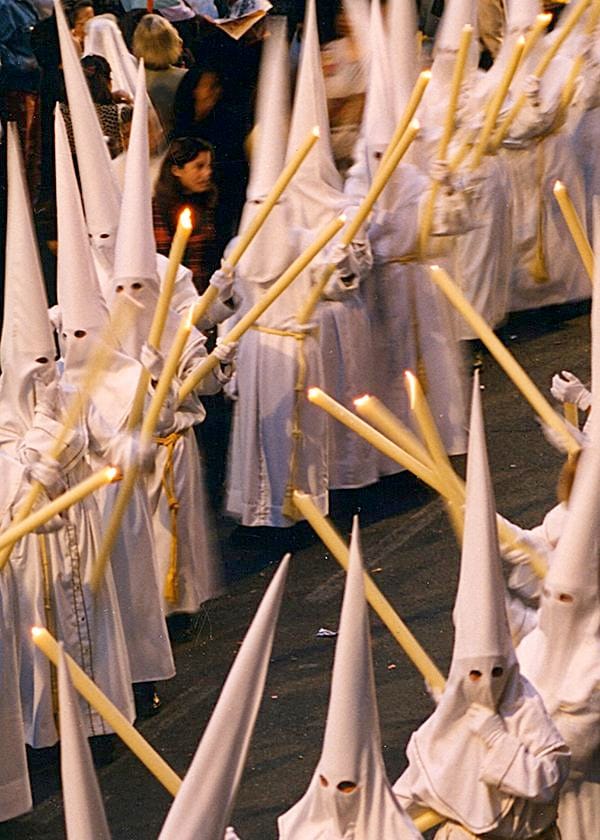Nazarenos vestidos de blanco durante la Semana Santa de Málaga.