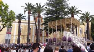 Paso de la Virgen de Consolación recorriendo las calles de Lebrija ante el público durante la Semana Santa.
