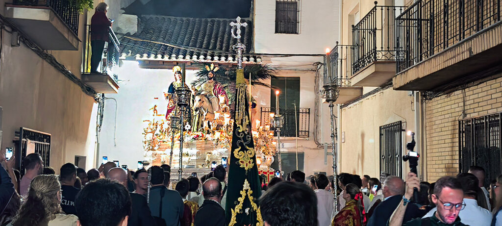 Numerosos espectadores contemplan el paso de misterio de Jesús de la Victoria durante su recorrido nocturno.