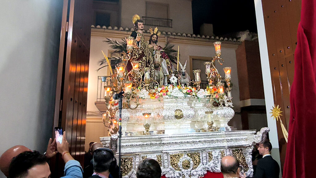Paso plateado de Jesús de la Victoria frente a la entrada de la Casa de Hermandad durante el regreso nocturno.