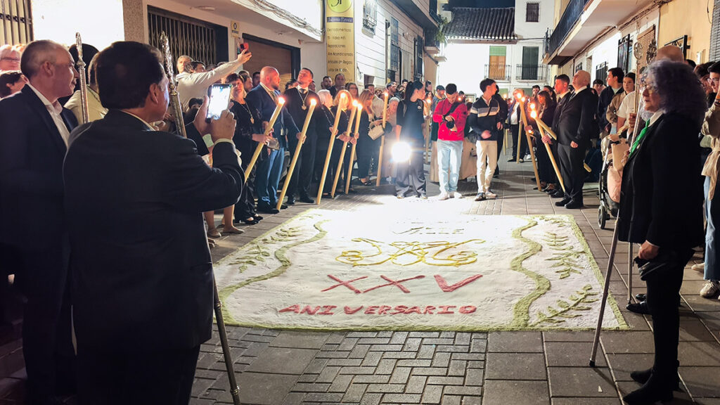 Alfombra decorativa sobre el pavimento de una calle de Padul, rodeada de espectadores.