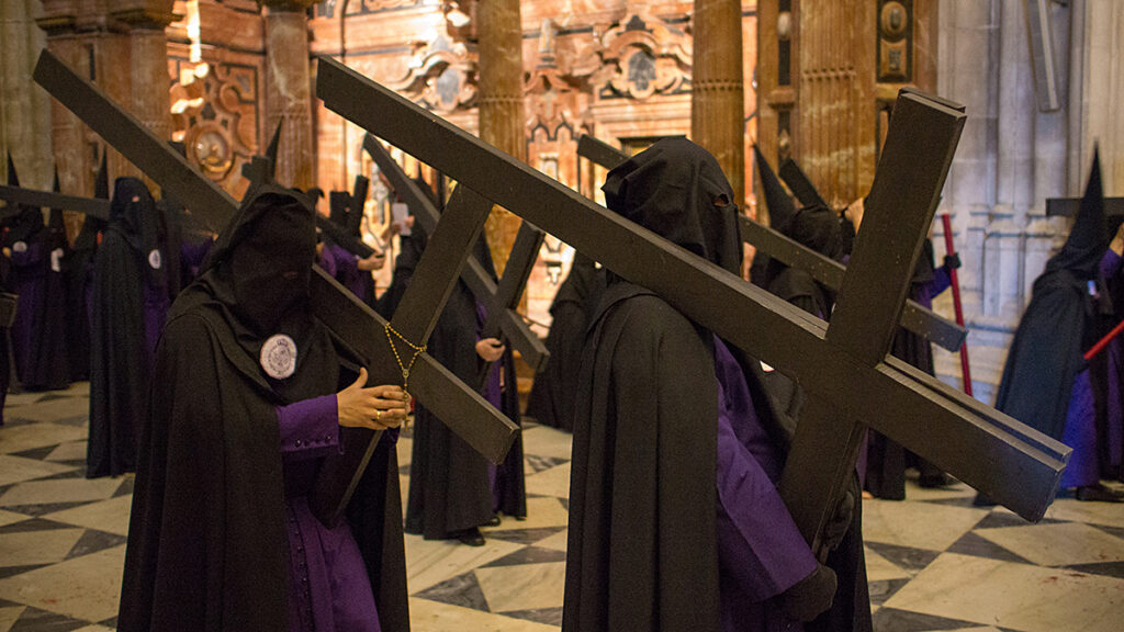Penitentes de la Hermandad de San Bernardo atravesando el interior de la Catedral de Sevilla durante la Semana Santa.