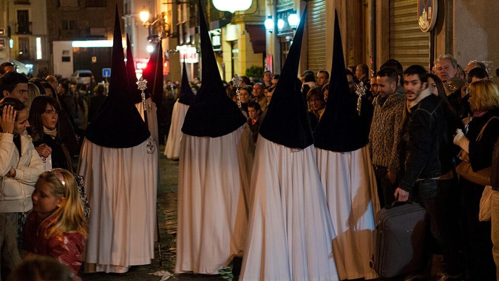 Procesión nocturna de Semana Santa en Granada recorriendo el espacio urbano.