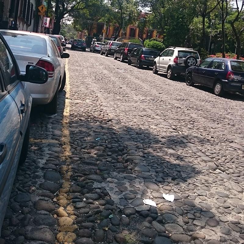 Calle empedrada en San Ángel, Ciudad de México, con pavimento tradicional de piedra.