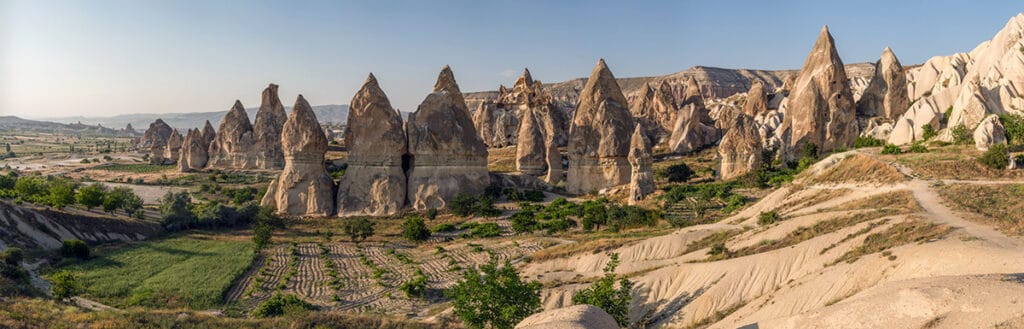 Formaciones de toba volcánica (‘chimeneas de hadas’) en un valle de Capadocia, bajo cielo claro.