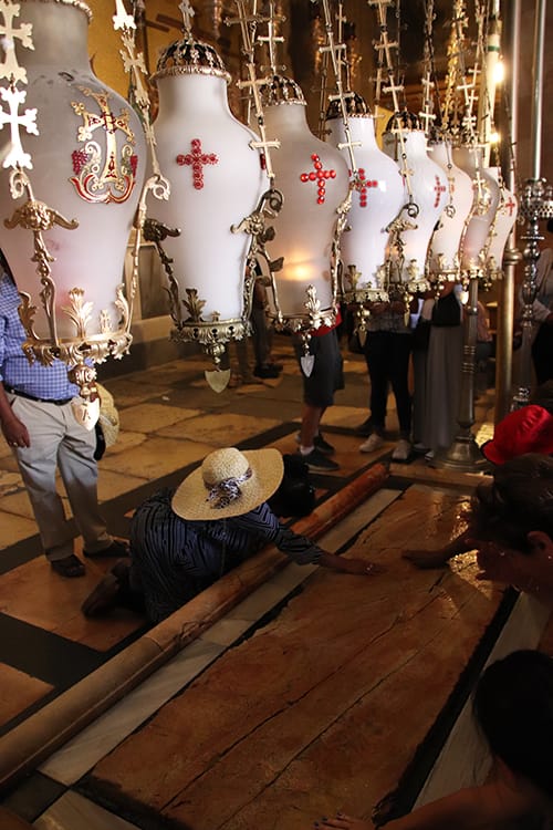 La Piedra de la Unción en la Iglesia del Santo Sepulcro, con lámparas votivas colgantes .