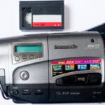 Videocámara Panasonic VHS-C con casete VHS-C, fotografiada sobre fondo neutro.