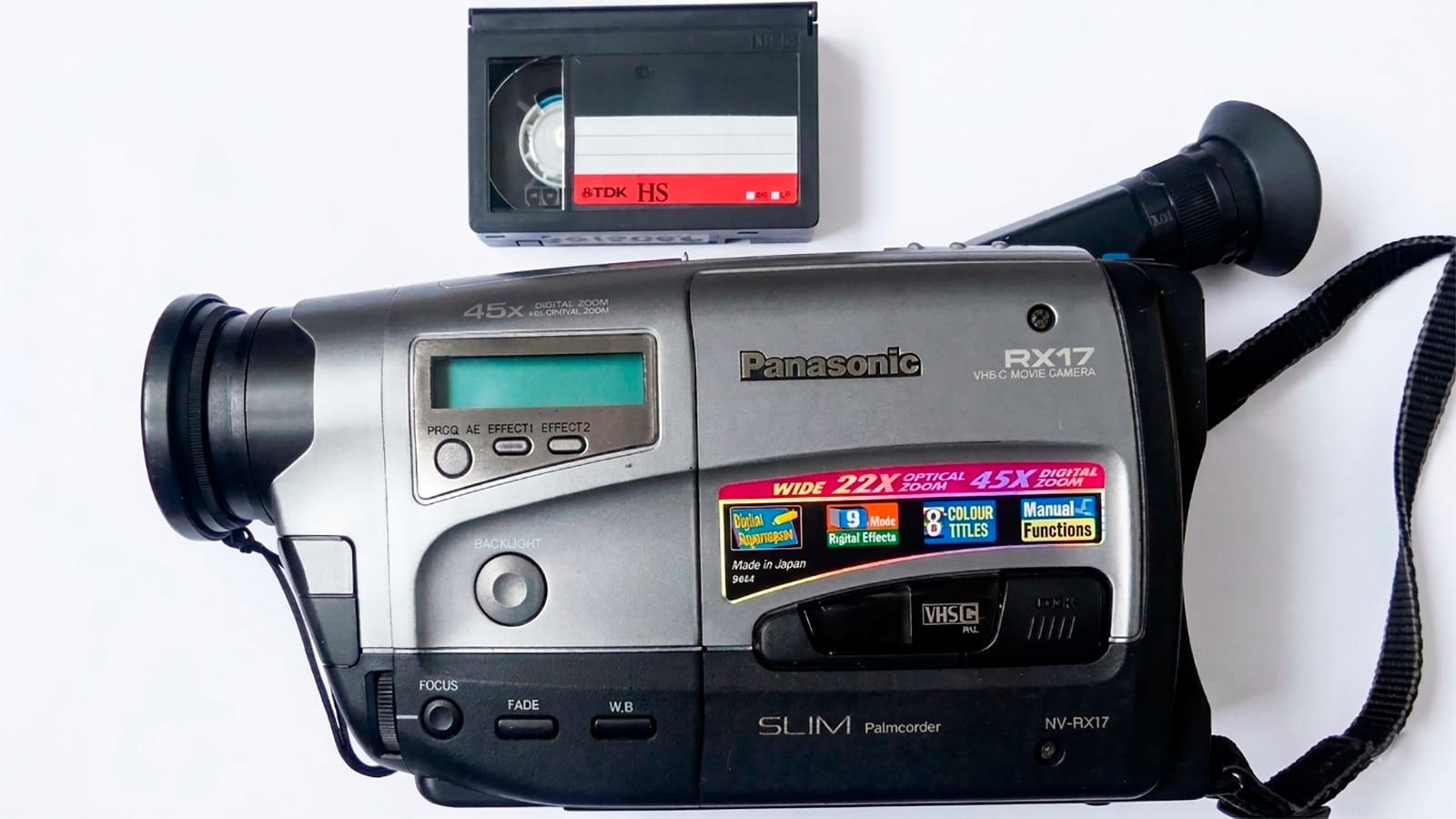 Videocámara Panasonic VHS-C con casete VHS-C, fotografiada sobre fondo neutro.