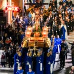 Procesión de Semana Santa en Alicante con nazarenos y paso en un encuadre amplio.