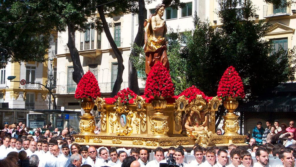 Trono de Semana Santa en Málaga avanzando entre el público. 