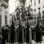 Escena histórica de la Semana Santa de Sevilla, hacia 1926, con público y cortejo ocupando el espacio urbano.