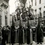 Escena histórica de la Semana Santa de Sevilla, hacia 1926, con público y cortejo ocupando el espacio urbano.
