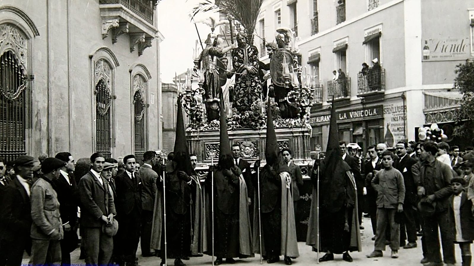 Escena histórica de la Semana Santa de Sevilla, hacia 1926, con público y cortejo ocupando el espacio urbano.