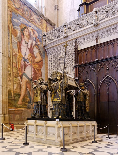 Sepulcro de Cristóbal Colón en la Catedral de Sevilla, sostenido por cuatro figuras y con escudos heráldicos.