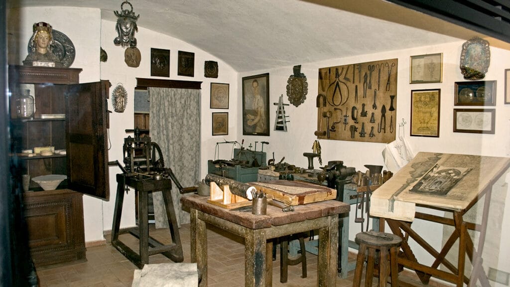 Taller de orfebrería con herramientas y mesa de trabajo.