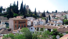 Calle del Albaicín de Granada con casas encaladas y trazado tradicional del barrio.