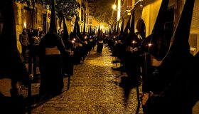 Nazarenos de la Cofradía del Calvario de Sevilla durante la Semana Santa, vestidos con túnicas oscuras.