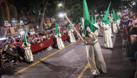 Nazarenos con capirotes verdes de la Hermandad de Nueva Esperanza durante la Semana Santa de Málaga.