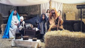 Escena del pesebre en interior, con figurantes caracterizados, paja y animales en la Casa Grande.