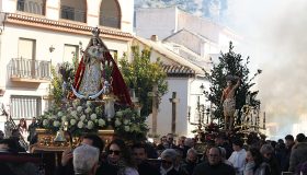 Los pasos avanzan entre el público en una calle de Padul, con humo al fondo.