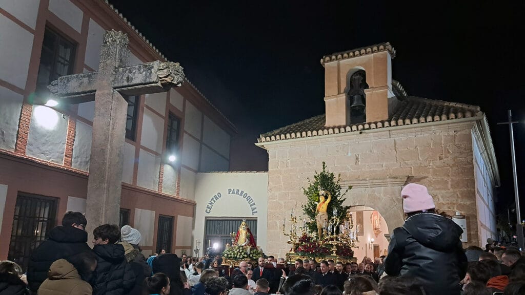 Los pasos avanzan entre el público en una calle de Padul, con humo al fondo.