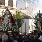 Los pasos avanzan entre el público en una calle de Padul, con humo al fondo.